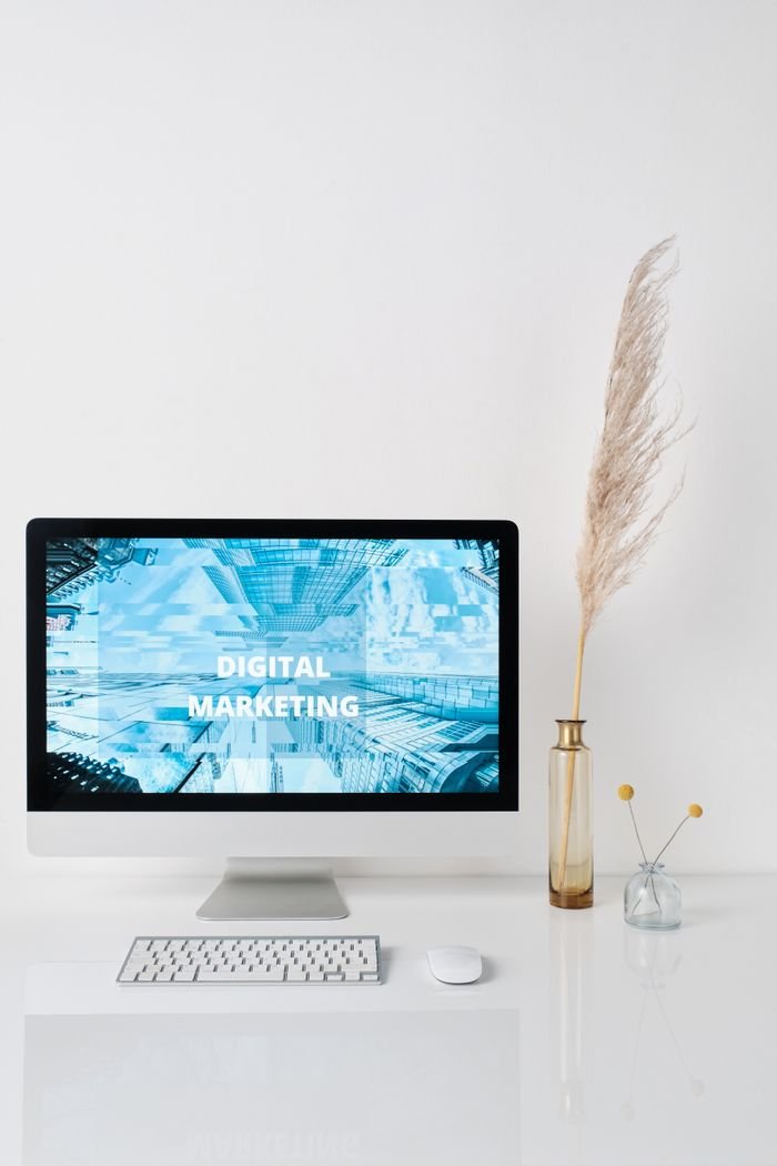 About Modern workspace featuring a monitor displaying digital marketing graphics on a minimalist desk.